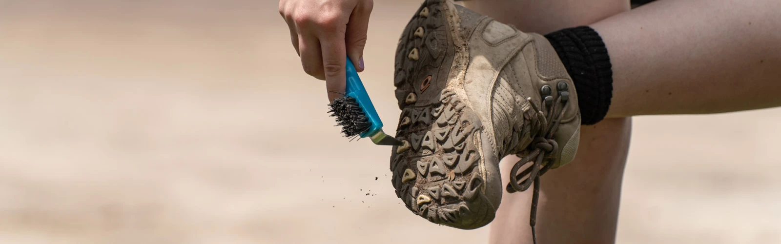boot_brush_ddg8647_kenauk_04jul2025_1920x1280_1 Person cleaning dirt off the sole of their shoe with a tool that has bristles and a sharp edge