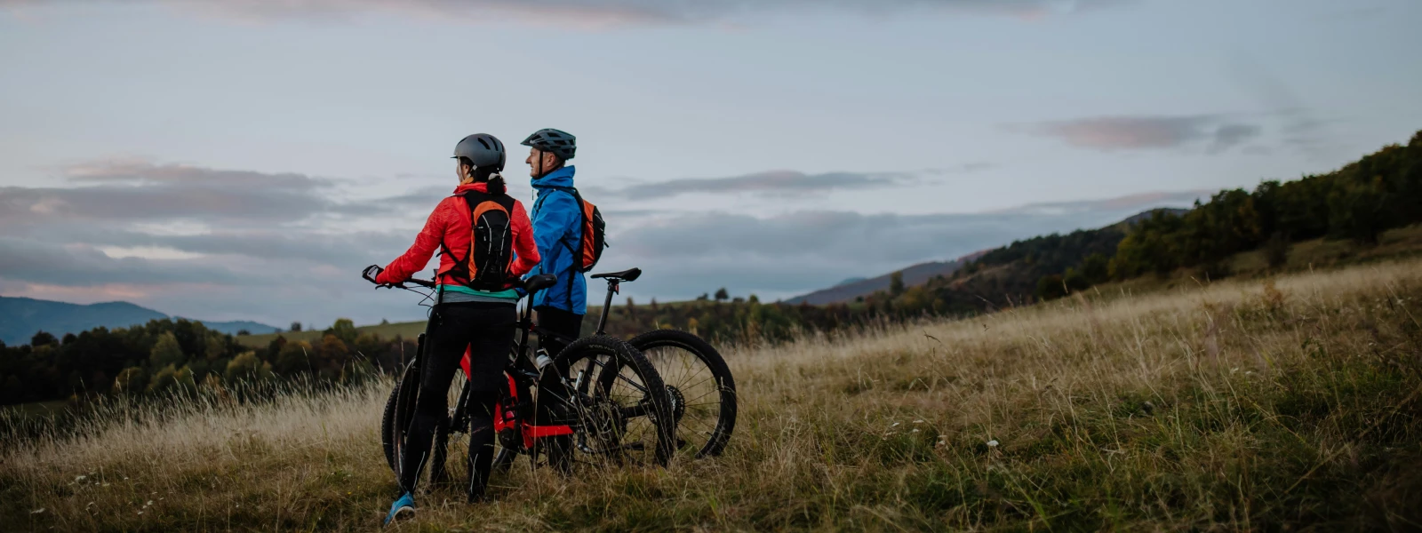 Two cyclists on a mountain looking out at the view