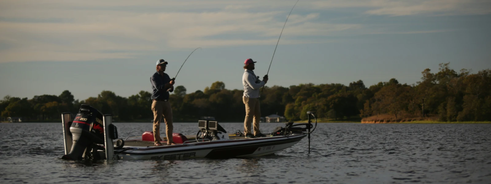 Two men on a boat fishing on a lake